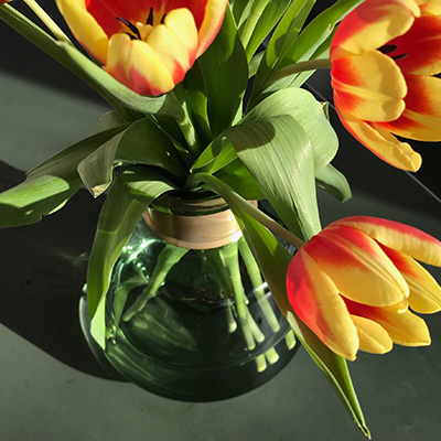 Glasvase gruen von nkuku mit Messingmanchette mit Tulpen